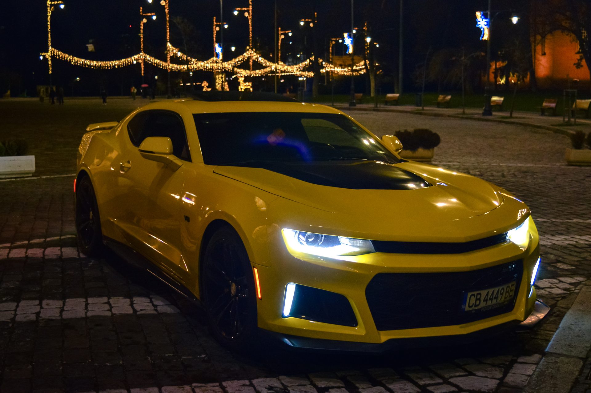Camaro нощен 3/4 изглед, коледни светлини на фона